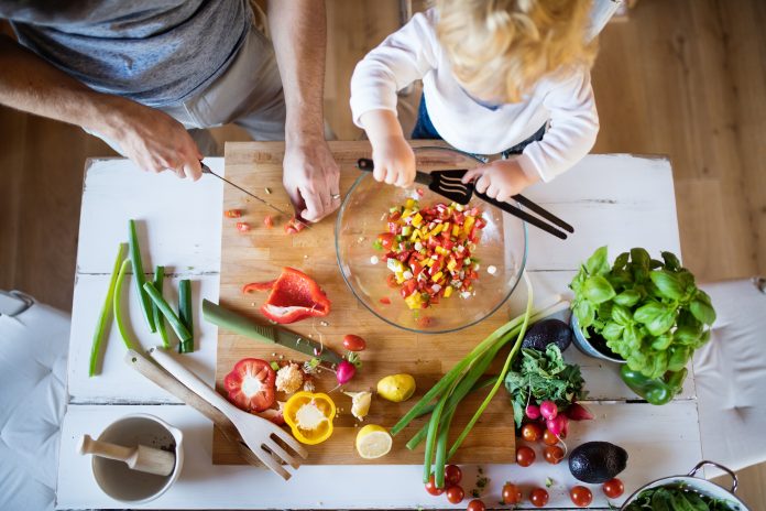 Young father with a toddler boy cooking.