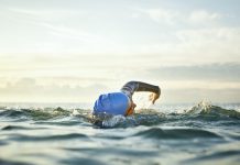 Determined woman swimming in sea. Mature female is enjoying water sport during sunset. She is representing healthy lifestyle.