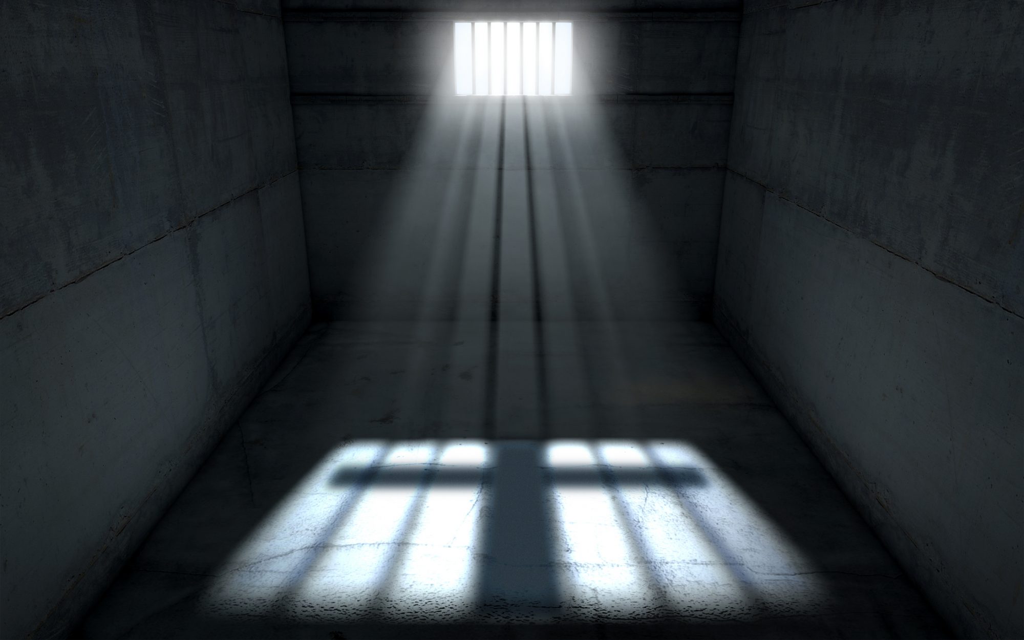 A jail cell interior with a barred up window and light rays penetrating through it casting an image of a crucifix - 3D render