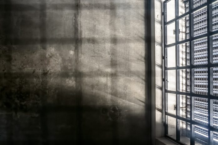 concrete walls and metal bars of prison cell