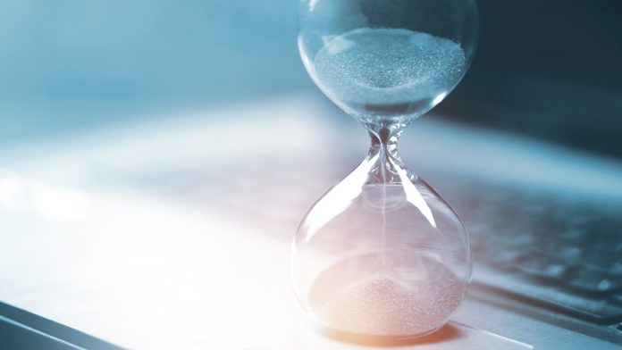 Hourglass on laptop computer Time management and countdown to deadline