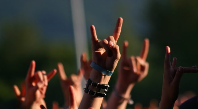 Hands in air at concert making rock sign gesture