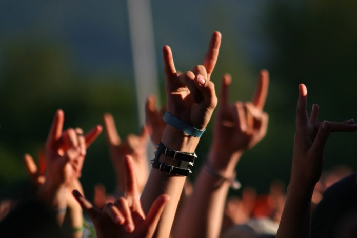 Hands in air at concert making rock sign gesture