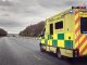 British ambulance responding to an emergency in hazardous bad weather driving conditions on a UK motorway