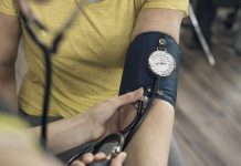 Nurse Taking Patients Blood Pressure and Pulse In The Gym