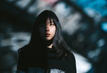 A portrait of a young Asian woman while half of her face is lit by the sun and the other half is in the shadow.