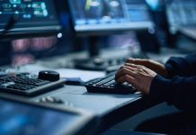 Close Up of a Professional Office Specialist Working on Desktop Computer in Modern Technological Monitoring Control Room with Digital Screens. Manager Typing on keyboard and Using Mouse.