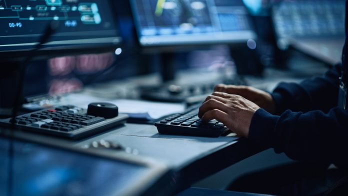 Close Up of a Professional Office Specialist Working on Desktop Computer in Modern Technological Monitoring Control Room with Digital Screens. Manager Typing on keyboard and Using Mouse.