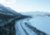 Aerial shot of fields, mountains and forest covered in snow in Whitehouse, Yukon, Canada