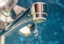 A drop of water drips from a leaky faucet