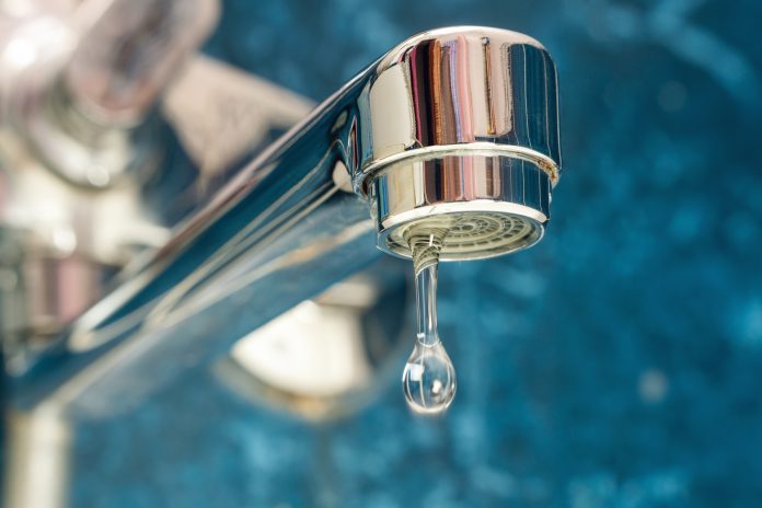 A drop of water drips from a leaky faucet