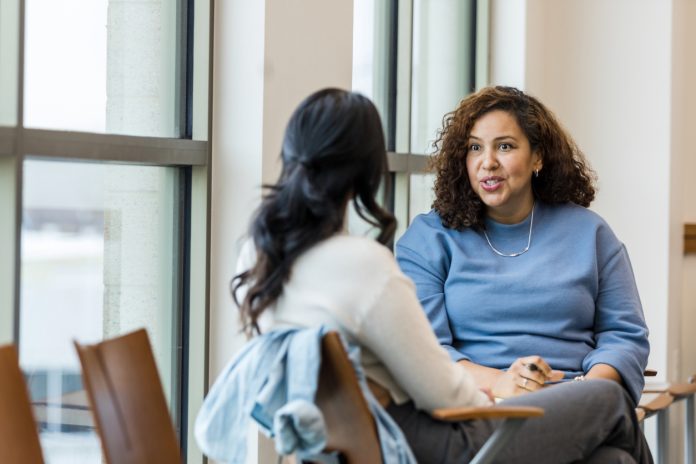 Supervisor meets with mid adult female employee to mentor her regarding a new position she is interested in