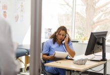 Female nurse makes patient calls as unrecognizable doctor arrives