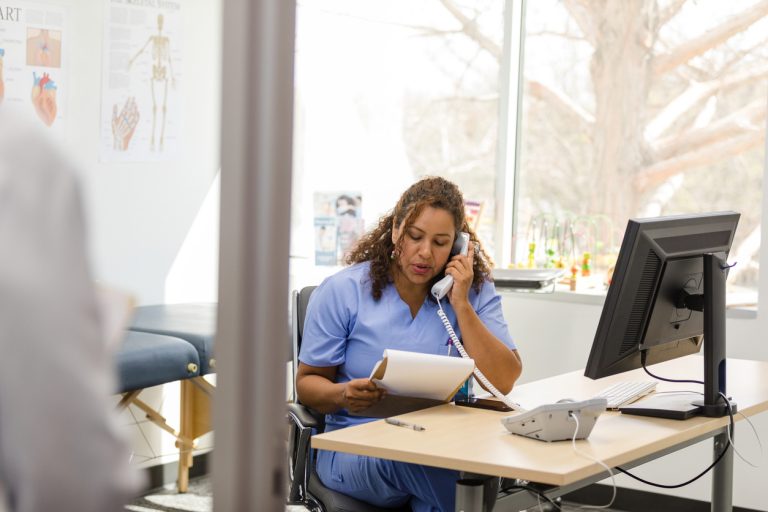 Female nurse makes patient calls as unrecognizable doctor arrives