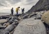 Family looking for fossils at the Lyme Regis Fossil Beach in Dorset, United Kingdom