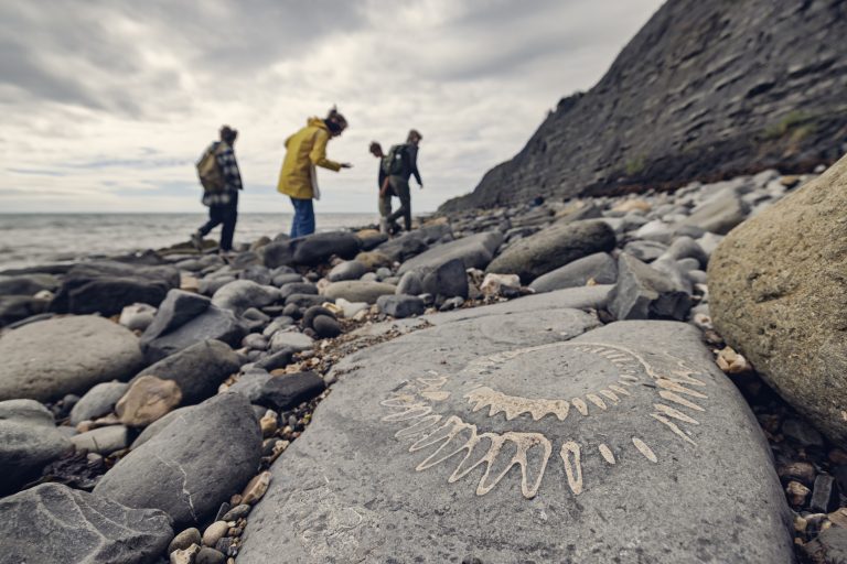 Family looking for fossils at the Lyme Regis Fossil Beach in Dorset, United Kingdom