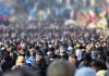 Crowd of anonymous people on street in city center, selective focus