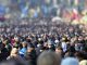 Crowd of anonymous people on street in city center, selective focus