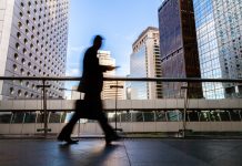 Blurred motion silhouette of businessman walking in Hong Kong’s Central District elevated walkway