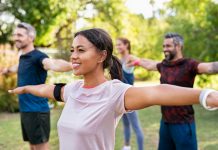 Mixed race woman exercising in park with mature friends