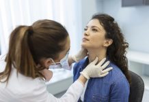 Endocrinologist examining throat of young woman in clinic. Women with thyroid gland test . Endocrinology, hormones and treatment. Inflammation of the sore throat