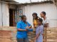 Community Nurse talking to teenage girls in an informal settlement infront of a shack