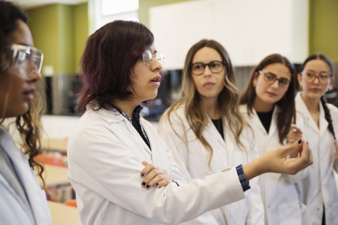 Girls in STEM, female science college students in classroom.