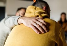 Man embracing his friend who is sharing his story at the group therapy session