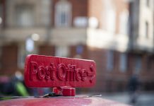 Old red cast iron sign to the Post Office in London, UK