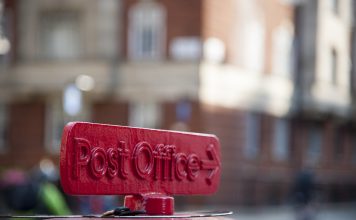 Old red cast iron sign to the Post Office in London, UK