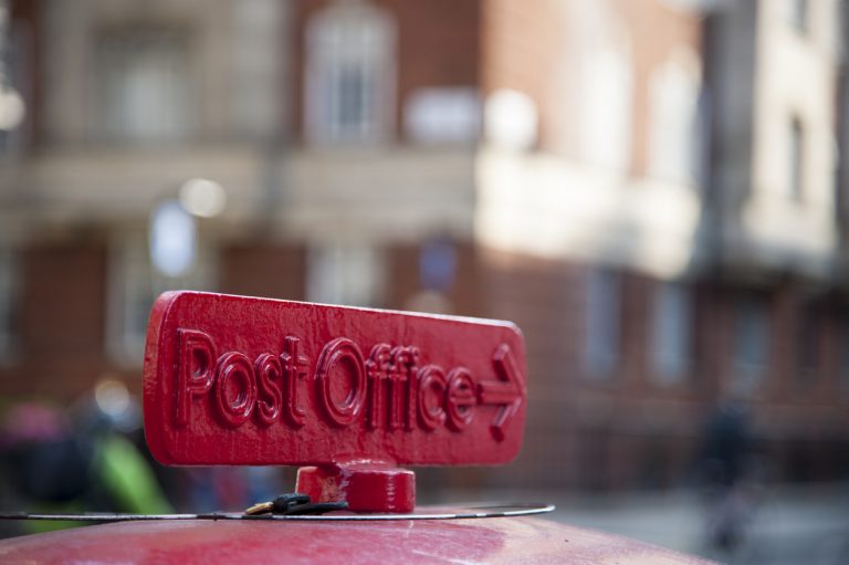 Old red cast iron sign to the Post Office in London, UK