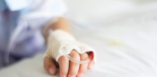 Saline intravenous (iv) drip in a Children's patient hand