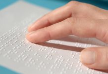 Blind woman reading text in braille