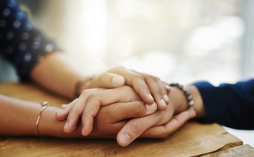 person holding women hand in comfort