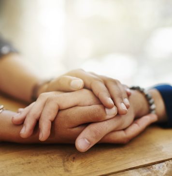 person holding women hand in comfort