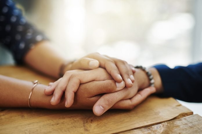 person holding women hand in comfort