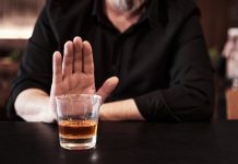 Man refuses or rejects to drink alcohol at the pub. Alcohol addiction treatment, sobriety and drinking problem.