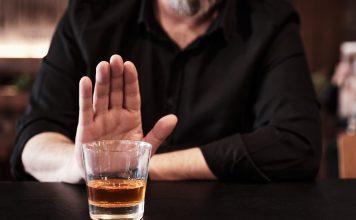 Man refuses or rejects to drink alcohol at the pub. Alcohol addiction treatment, sobriety and drinking problem.