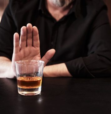 Man refuses or rejects to drink alcohol at the pub. Alcohol addiction treatment, sobriety and drinking problem.