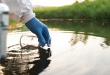 Environment engineer Collect samples of wastewater from industrial canals in test tube, Close up hand with glove Collect samples of wastewater from industrial canals in test tube. mobile water laboratory check