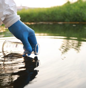Environment engineer Collect samples of wastewater from industrial canals in test tube, Close up hand with glove Collect samples of wastewater from industrial canals in test tube. mobile water laboratory check