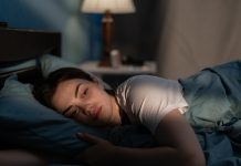 Young sad woman lying in bed late at night trying to sleep suffering insomnia. Girl in bed scared on nightmares looking worried and stressed. Sleeping disorder and insomnia concept