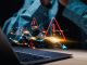 Businessman use laptop with virtual world economic growth chart with red warning sign for caution in investing economic situation warning, Business investment risks.