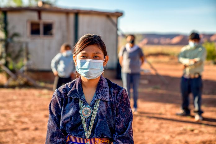 Navajo Family Social Distancing with Covid-19 Masks outside their home in Monument Valley Arizonaa