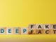 Dice form the words DEEPFAKE on wooden cube block. Deepfake concept matching facial movements.