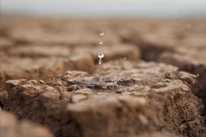 Water drop to dry cracked land metaphor lack of rain, water crisis, Climate change and Environmental disaster