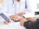 Doctor and patient examining x-ray images from digital tablet