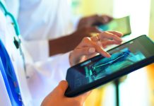 Doctor's in a row working looking at CT Scan with digital tablets.