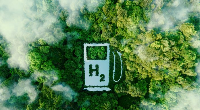 A lake in the shape of a hydrogen filling station used as a concept to illustrate the environmental friendliness of hydrogen and its potential as the fuel of the future. 3d rendering.
