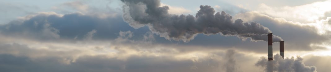 Heat station pipes, smoke. Smoking pipes, white smoke. Gray dramatic sky sky as background. Chimneys, concept of industry and ecology, heating season, global warming. Panoramic image